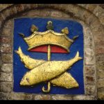 Wappen mit Goldfischen an der Hauswand